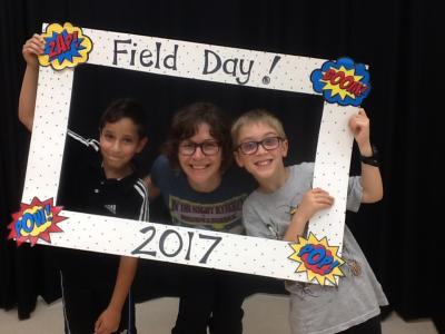 photo of teacher and students holding field day photo booth frame