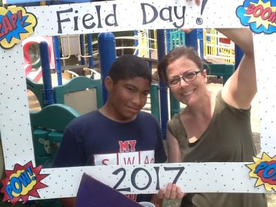 photo of teacher and student holding field day photo booth frame